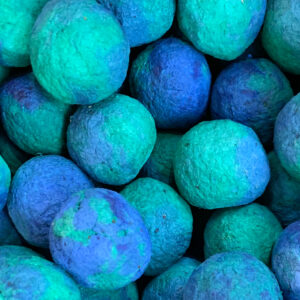Close up on bulk seed bombs made from paper waste that are colored to resemble little globes