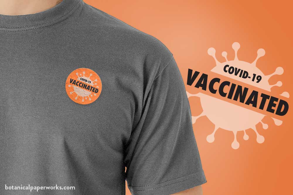 A promotional pin on a t-shirt that says COVID-19 VACCINATED. Designed for vaccination campaigns.