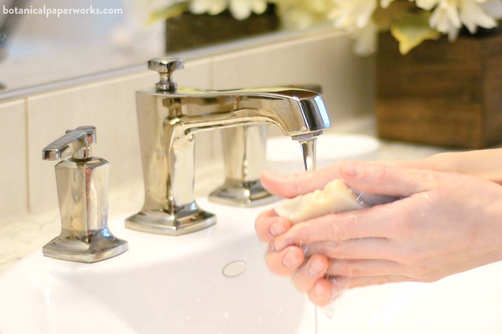 A person washing their hands with oatmeal handmade soap by Botanical PaperWorks