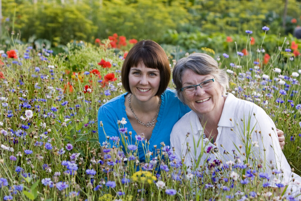Heidi Reimer-Epp and Mary Reimer, Co-Founders of Botanical PaperWorks seed paper company in a field of wildflowers