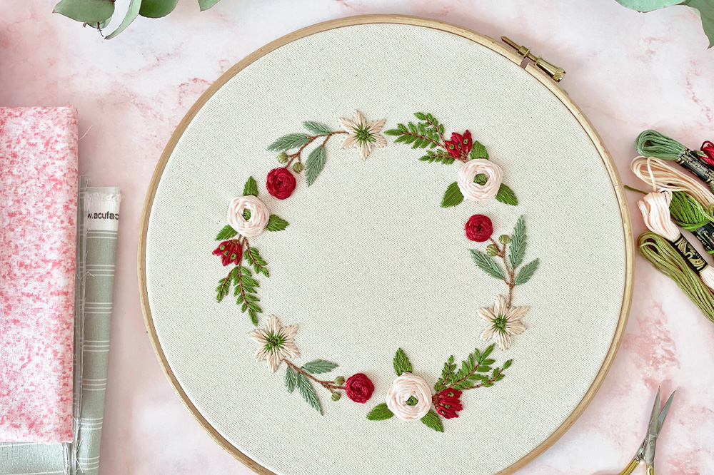 an embroidery hoop with a floral wreath design