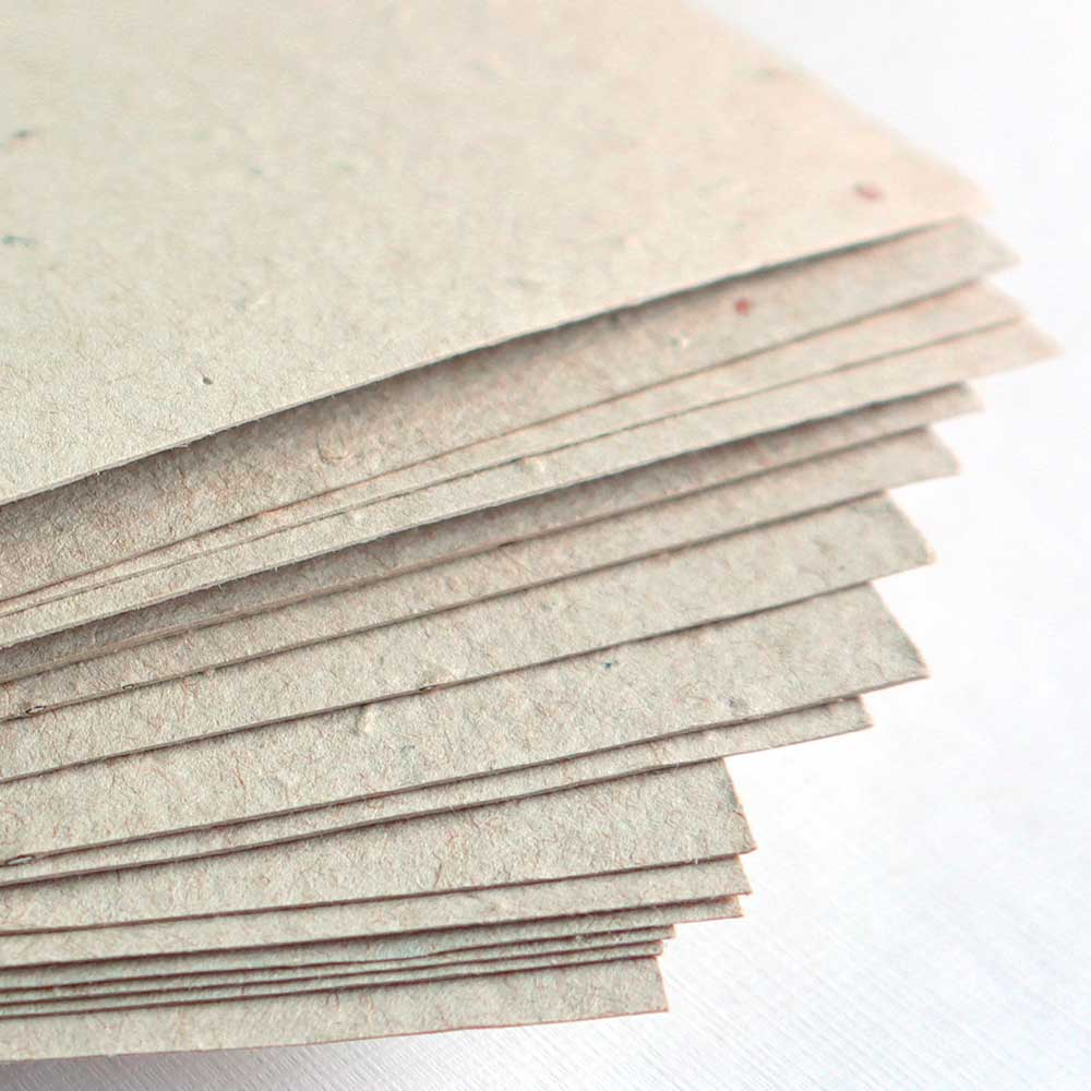 Stack of tabloid size Eco Natual Seed Paper, a naturally colored, light brown kraft seed paper where the waste paper it’s made with is also recycled unbleached content.