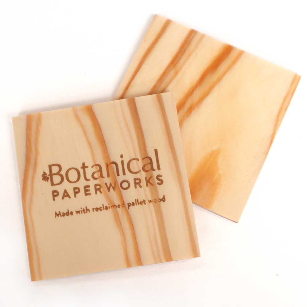 Upcycled wood coasters with a custom-engraved logo on one side