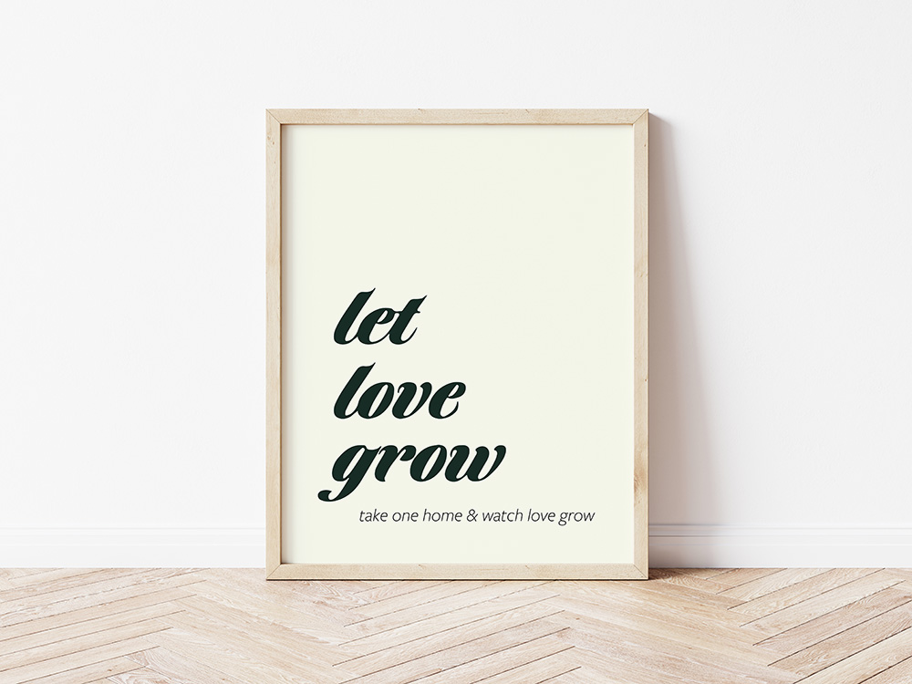 Let love grow sign in a large frame that is leaning up against a white wall