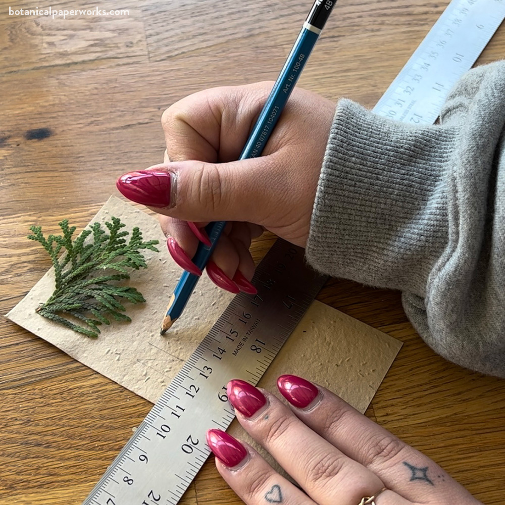 Writing a name on one of the place cards, using a ruler as a guide. 
