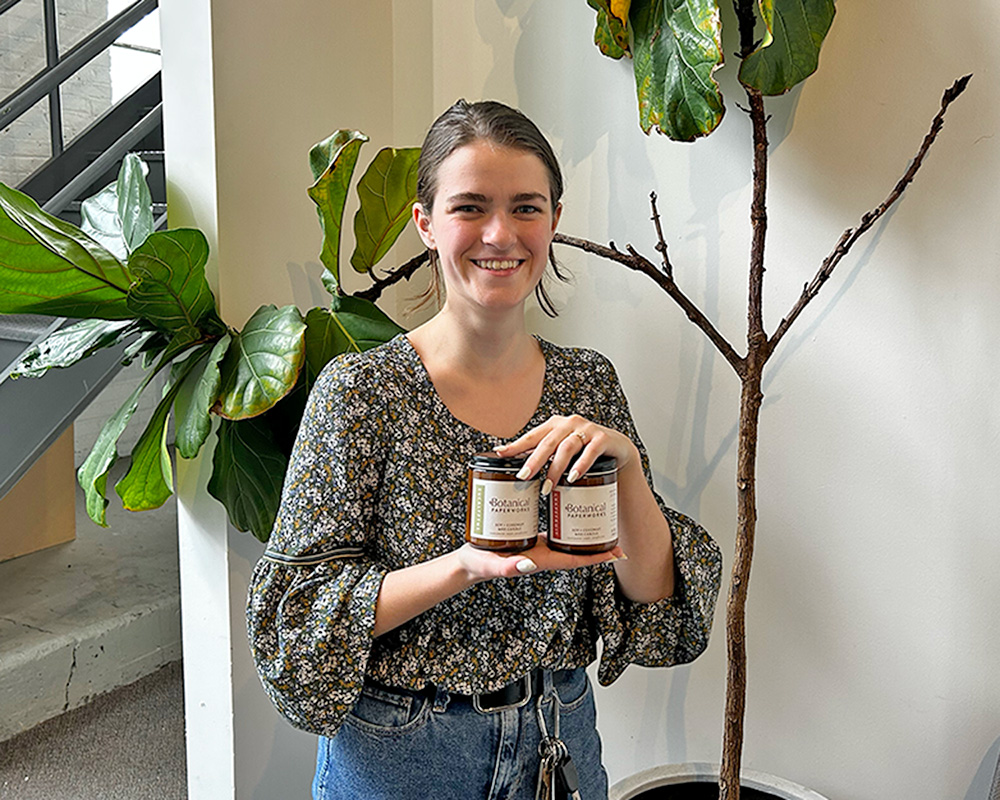 Grace holding up the eucalyptus and grapefruit candles that she made. 