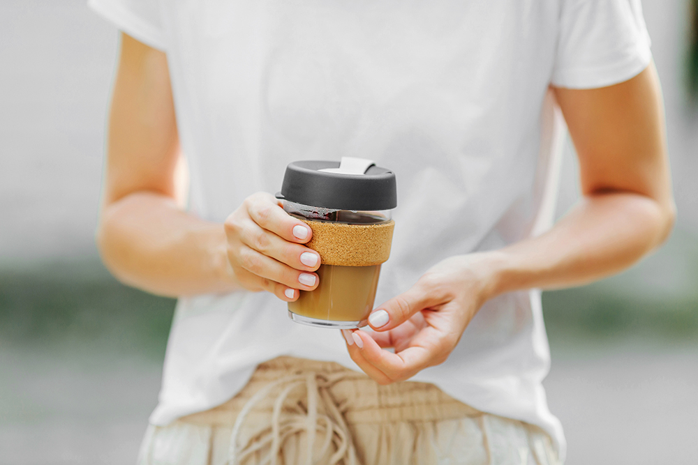 Female hands hold reusable coffee mug.  Sustainable lifestyle. Eco friendly concept.