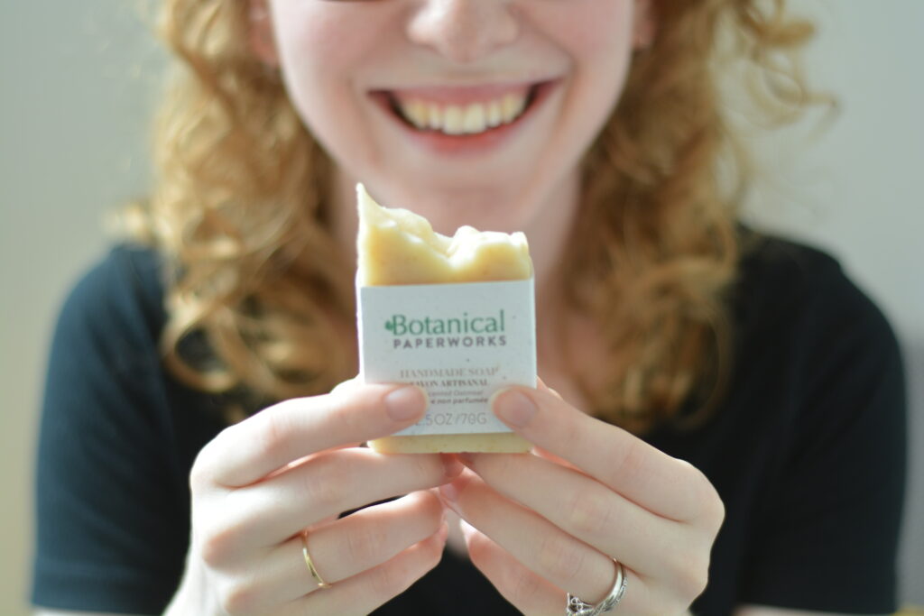 Image of a person holding handmade soap and smiling